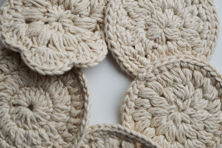 Close-up of hand-crocheted cotton pads. Every pad has a different size, shape and pattern. Undyed, organic cotton.
