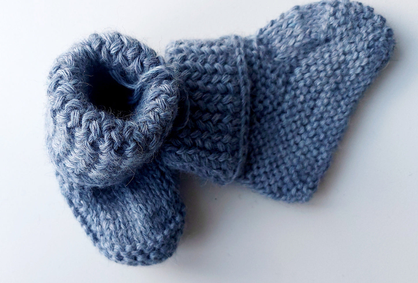 Handmade knitted baby socks in light blue with folded ankle cuffs, made from 100% baby alpaca wool—soft, stretchy, and perfect for little feet.