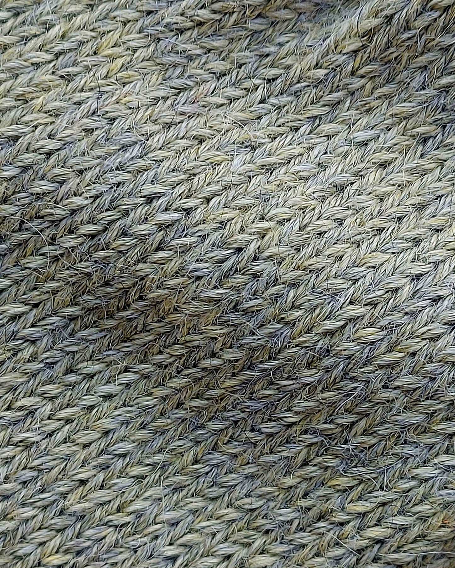 Close-up of the soft knitted texture of the handmade light green baby hat, made from 100% baby alpaca wool with a foldable edge and pompom.