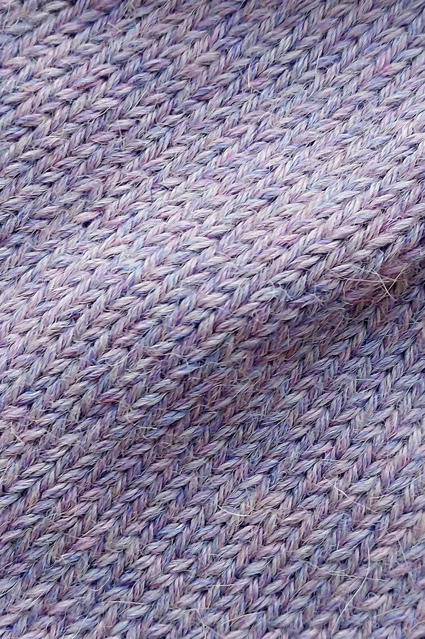 Close-up of the soft knitted texture of the handmade lila baby hat, made from 100% baby alpaca wool with a foldable edge and pompom.
