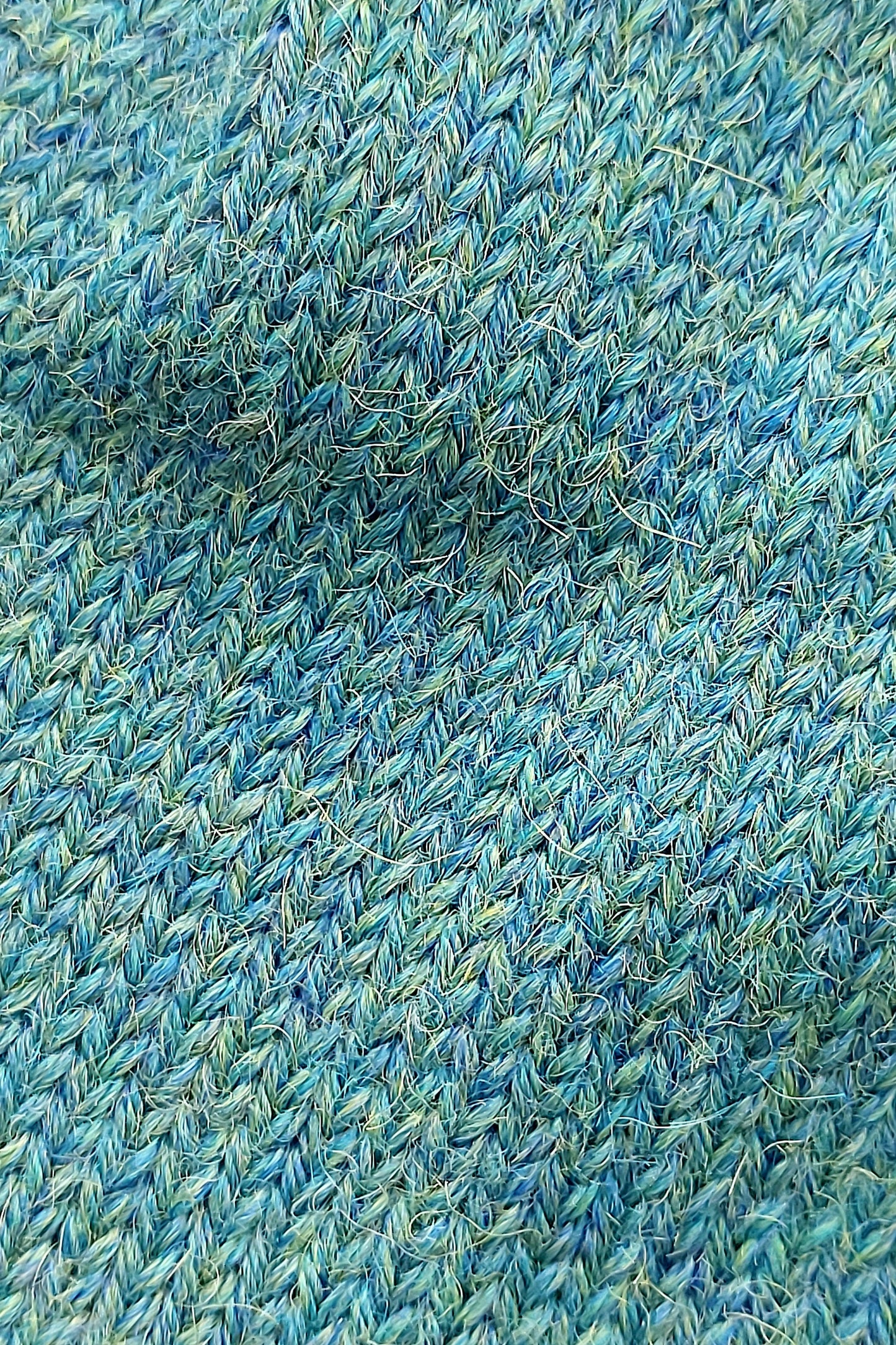 Close-up of the knitted texture on the handmade peacock blue baby hat, made from 100% baby alpaca wool.