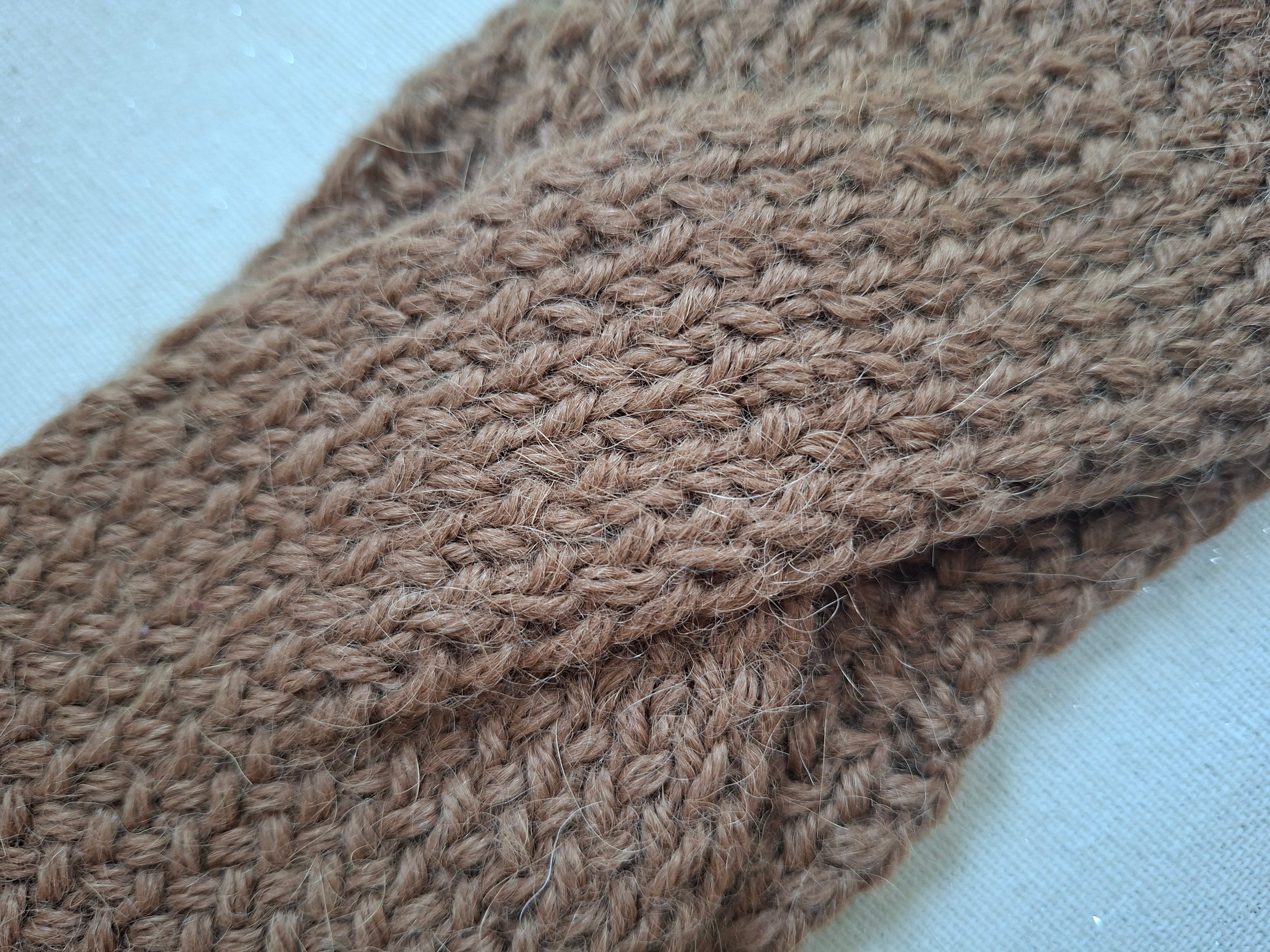 Close-up of a brown knitted fabric on a light blue background