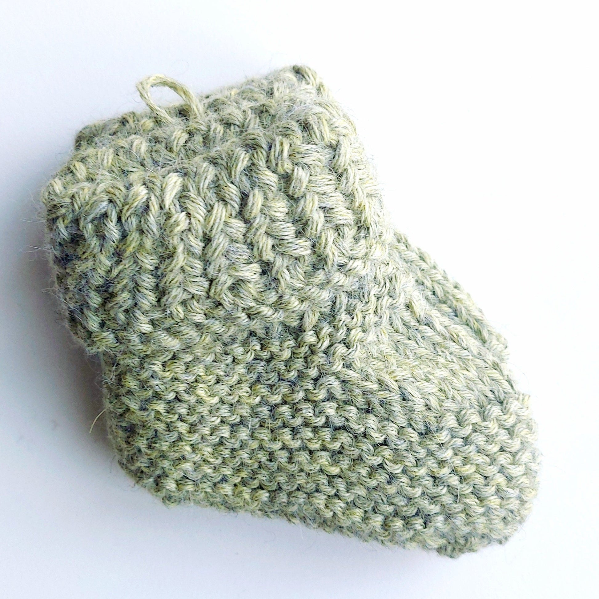 Handmade knitted baby socks in light green with folded ankle cuffs, made from 100% baby alpaca wool—soft, stretchy, and perfect for little feet.

