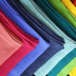 Alpaca wool scarves, folded and lined up in a rainbow of colors.